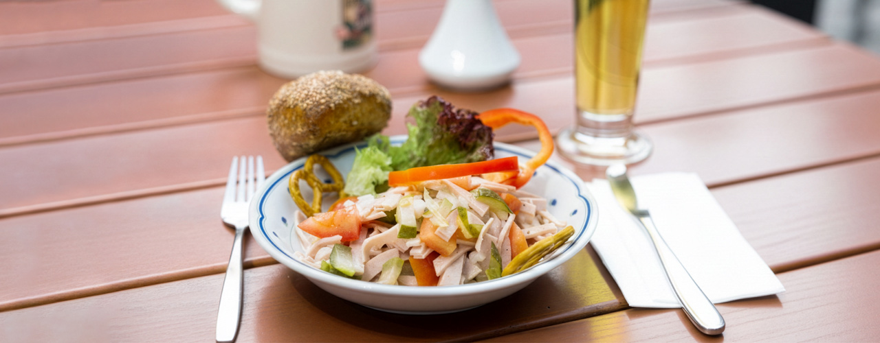 Wurstsalat mit Brötchen und Bier